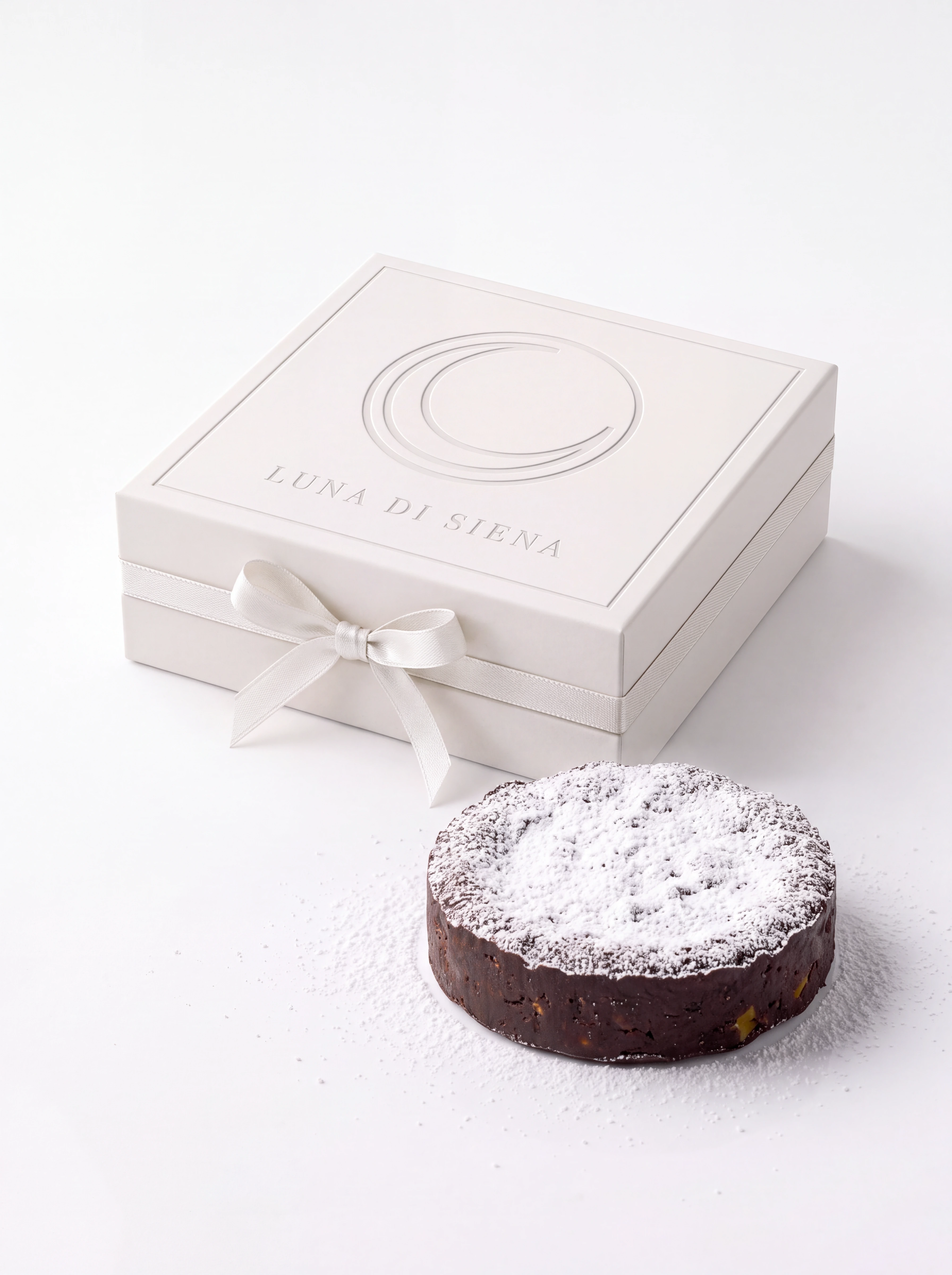 Caixa branca LUNA DI SIENA ao lado de um doce coberto com açúcar